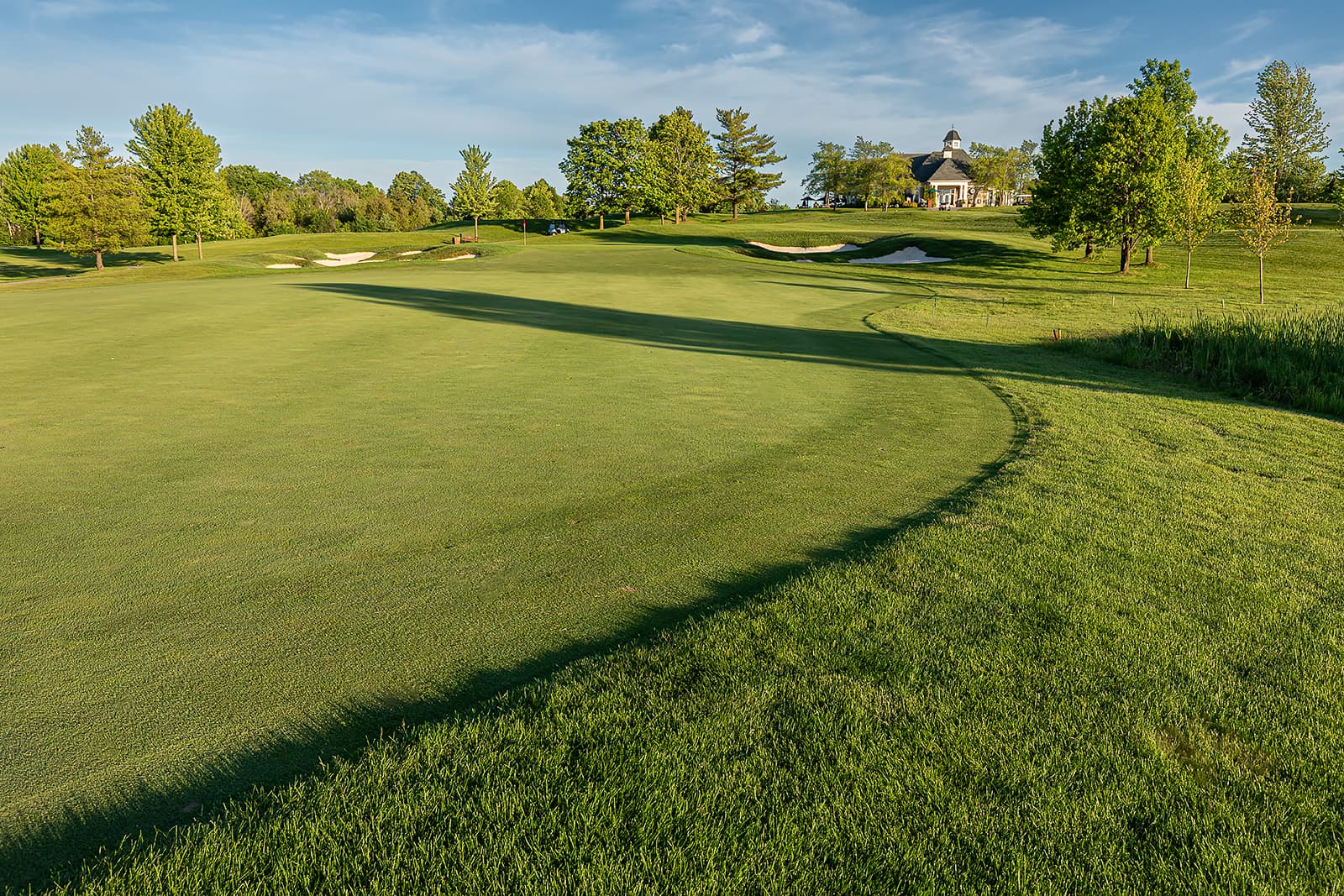 golf course fairway with sand bunkers and clubhouse