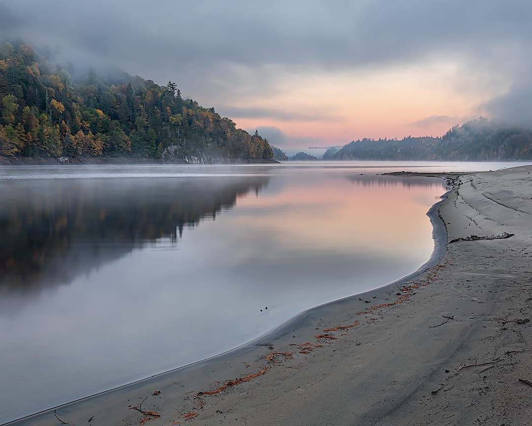 sunrise from a sandy beach with river, fog and autum colour